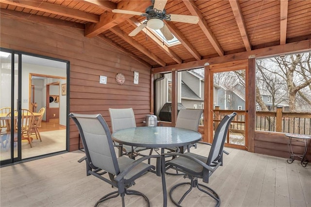 sunroom / solarium with vaulted ceiling with skylight, wood ceiling, and ceiling fan