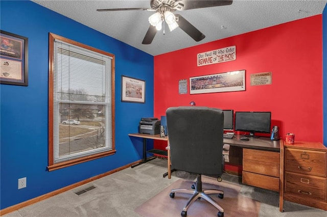 carpeted office space with ceiling fan and a textured ceiling