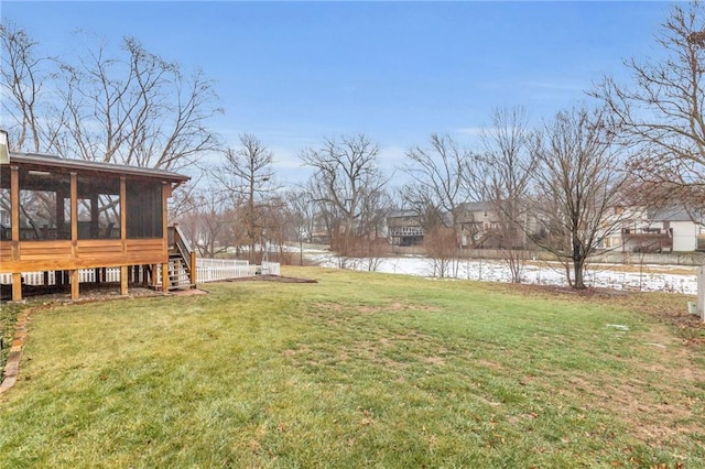 view of yard featuring a sunroom and a water view