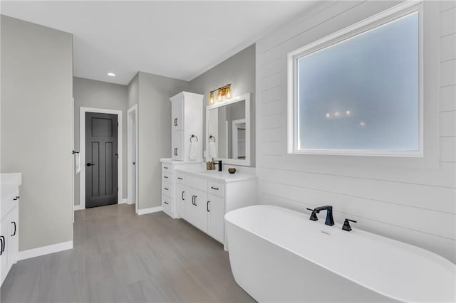 bathroom with vanity, wood-type flooring, and a bathing tub