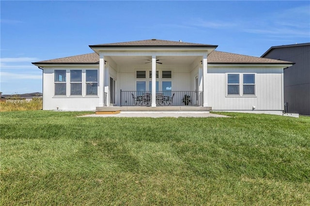 rear view of property with a lawn and ceiling fan