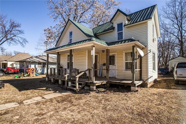 view of front facade featuring metal roof, a porch, and a playground