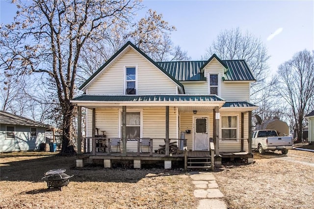 view of front facade featuring a fire pit, metal roof, and covered porch