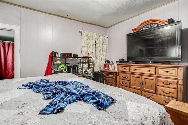 bedroom featuring a textured ceiling and ornamental molding