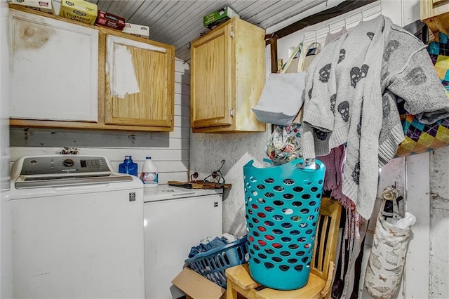 clothes washing area with washing machine and dryer and cabinet space