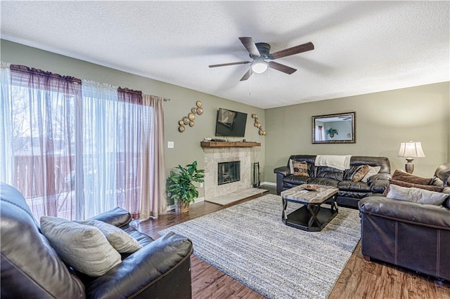 5933 Ridgeway Ave, Kansas City, MO 64133 - living room featuring a textured ceiling, a fireplace, and wood finished floors