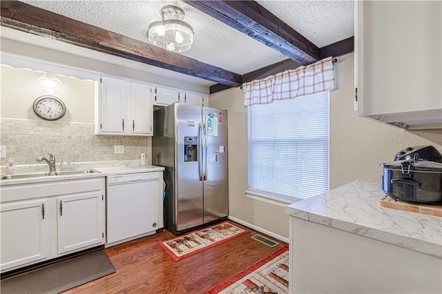 5933 Ridgeway Ave, Kansas City, MO 64133 - kitchen featuring stainless steel refrigerator with ice dispenser, a textured wall, white dishwasher, a sink, and a textured ceiling
