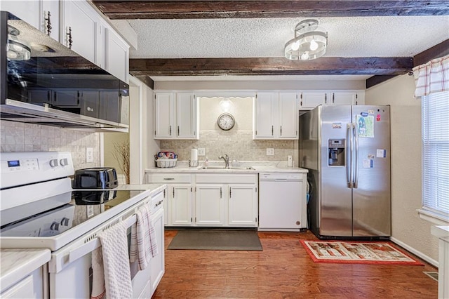 5933 Ridgeway Ave, Kansas City, MO 64133 - kitchen with a textured ceiling, white appliances, a sink, white cabinets, and beamed ceiling
