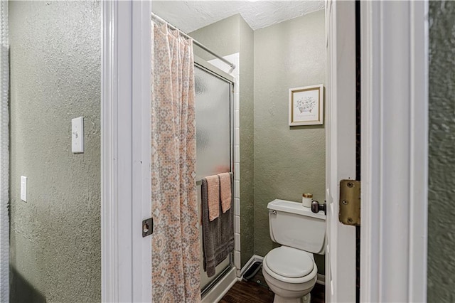5933 Ridgeway Ave, Kansas City, MO 64133 - full bath featuring a stall shower, baseboards, a textured wall, toilet, and wood finished floors