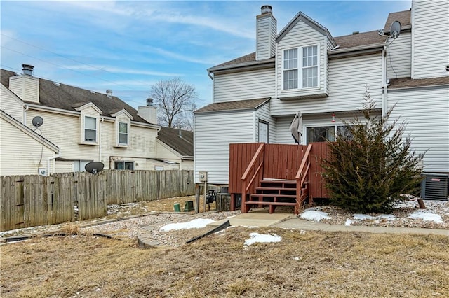5933 Ridgeway Ave, Kansas City, MO 64133 - back of house with central air condition unit, a chimney, fence, and a wooden deck