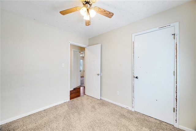 unfurnished bedroom featuring baseboards, carpet floors, a textured ceiling, and ceiling fan