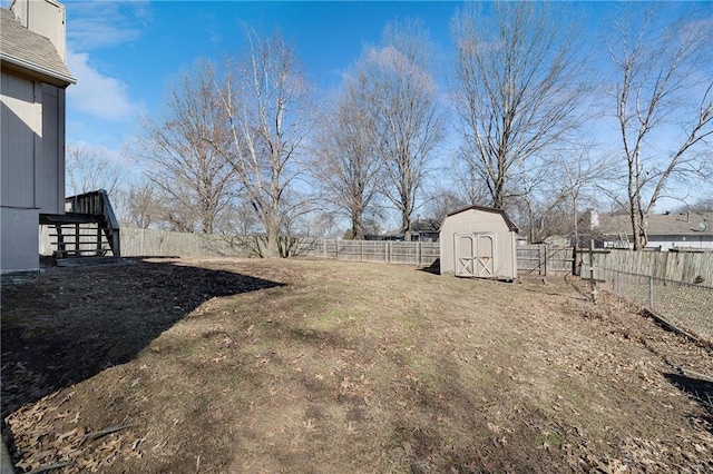 view of yard featuring an outbuilding, a fenced backyard, and a shed