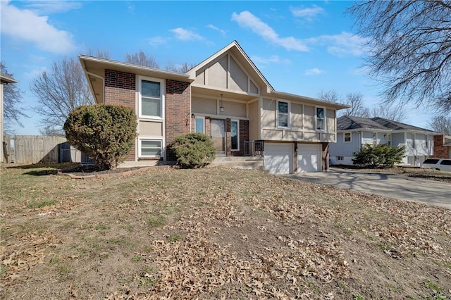 back of property featuring brick siding, concrete driveway, a garage, and fence