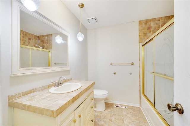 full bath featuring vanity, visible vents, baseboards, shower / bath combination with glass door, and toilet