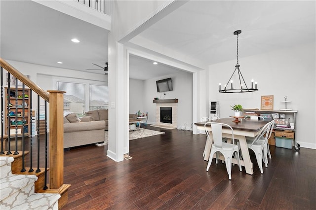 dining room featuring ceiling fan with notable chandelier and dark hardwood / wood-style flooring