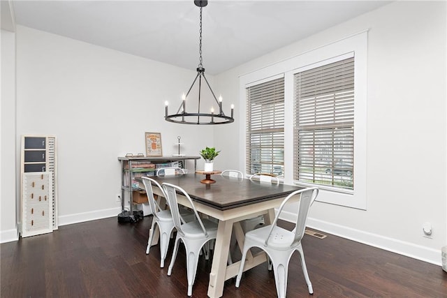 dining space with dark wood-type flooring and a chandelier