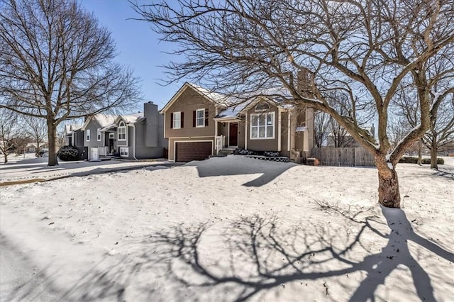 view of front of home featuring a chimney, an attached garage, and fence