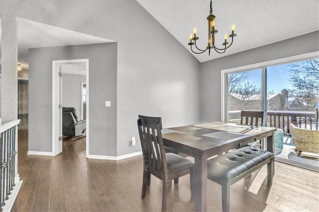 dining space featuring dark wood-style floors, baseboards, vaulted ceiling, and a notable chandelier