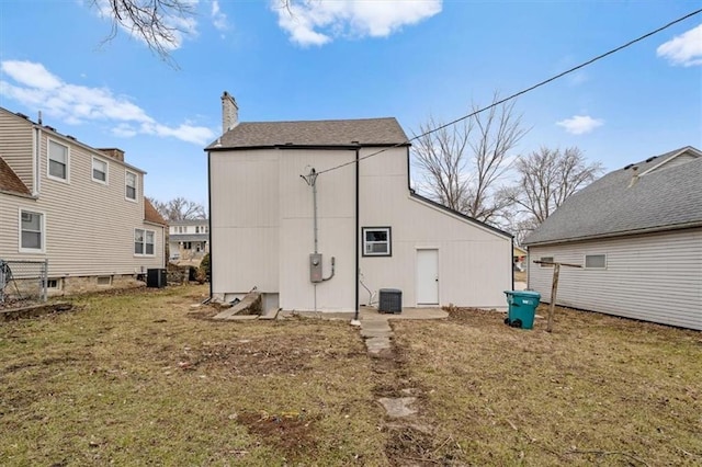 1111 Main St, Osawatomie, KS 66064 - back of property featuring a lawn, a chimney, and an outbuilding
