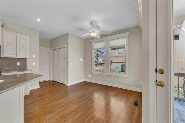 unfurnished dining area featuring a ceiling fan, baseboards, visible vents, light wood finished floors, and recessed lighting