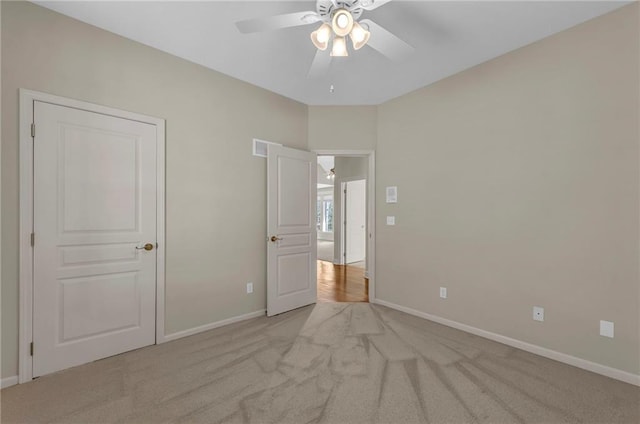 unfurnished bedroom with light colored carpet and baseboards