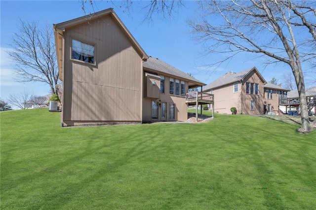 back of property with a yard, central AC unit, and a wooden deck