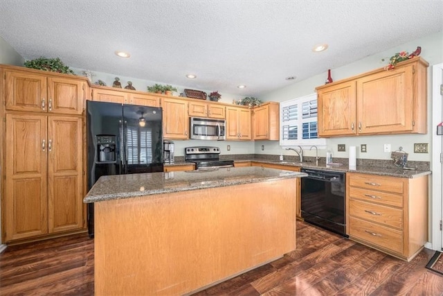 kitchen with a kitchen island, sink, dark stone countertops, dark hardwood / wood-style flooring, and black appliances