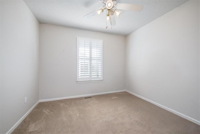 carpeted spare room with ceiling fan and a textured ceiling