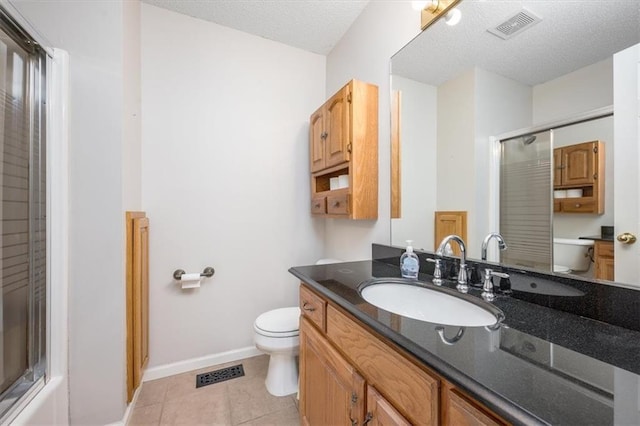 full bathroom featuring shower / bath combination with glass door, vanity, a textured ceiling, tile patterned floors, and toilet