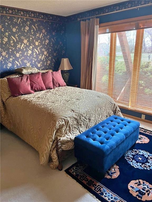 bedroom featuring carpet flooring, a textured ceiling, and wallpapered walls