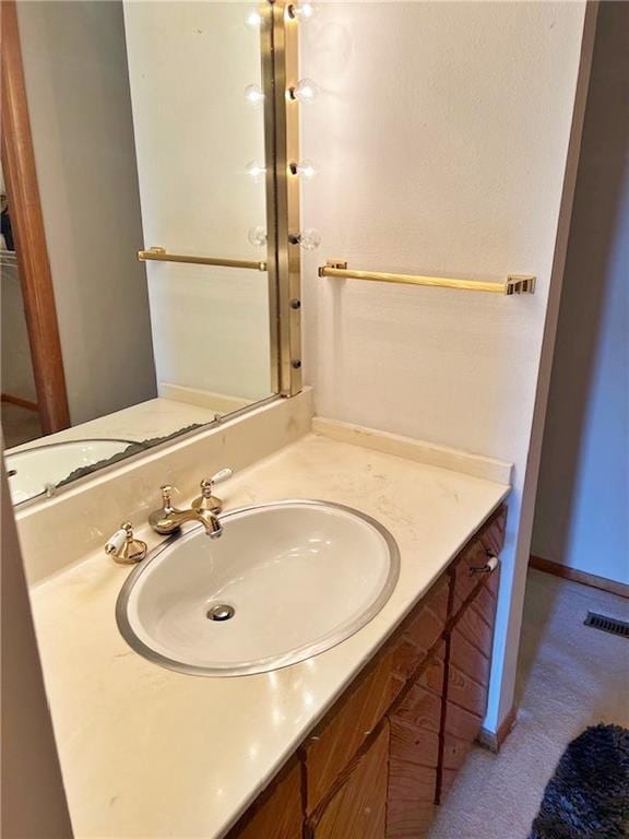 bathroom featuring baseboards, visible vents, and vanity