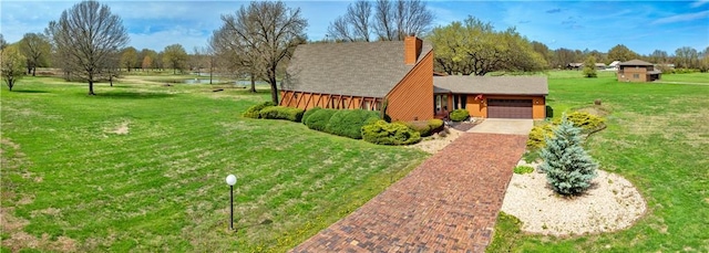 view of front of property featuring driveway, a front lawn, and an attached garage