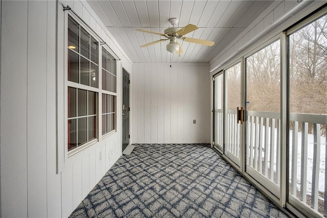 unfurnished sunroom with ceiling fan