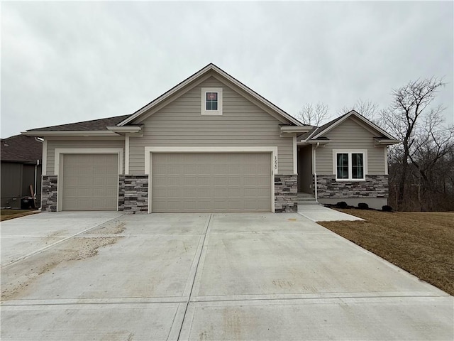 view of front of property with driveway, stone siding, and a garage