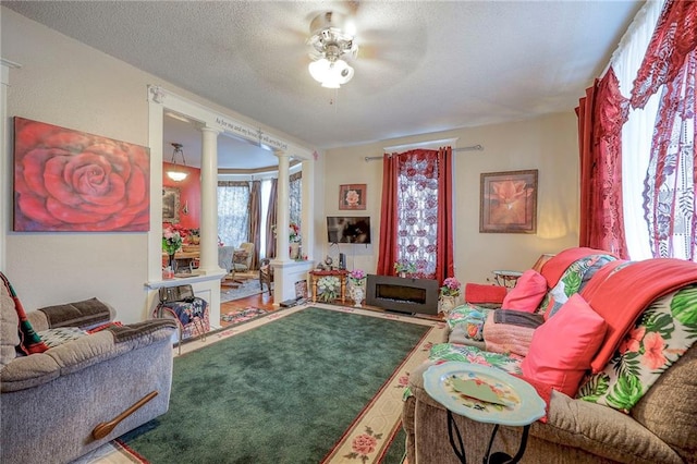 carpeted living room featuring ornate columns and a textured ceiling