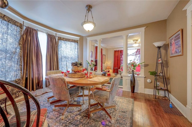 dining space with ornate columns and hardwood / wood-style floors