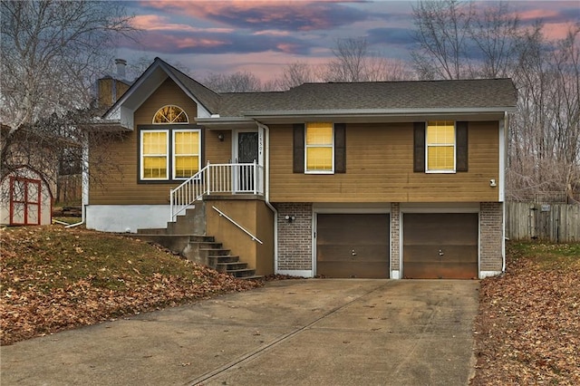 view of front of house with a garage, concrete driveway, and brick siding