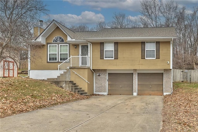 view of front of house with brick siding, a chimney, concrete driveway, an attached garage, and fence