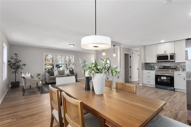 dining area featuring light wood-type flooring and baseboards