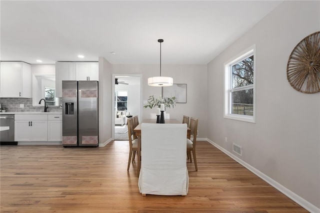 dining room featuring light wood-style floors, recessed lighting, visible vents, and baseboards