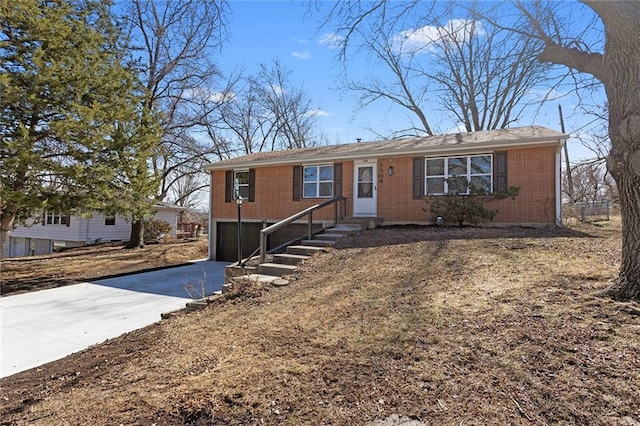 ranch-style home with an attached garage, concrete driveway, and brick siding