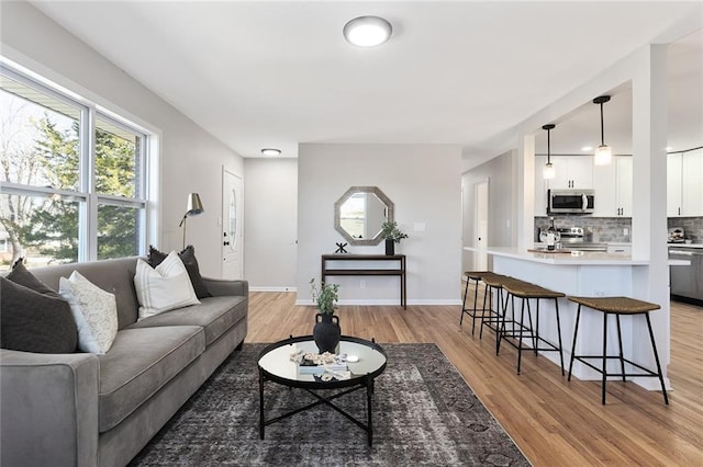 living area with light wood-type flooring and baseboards