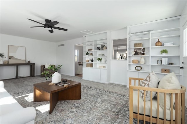 living room featuring a ceiling fan, carpet, visible vents, and baseboards