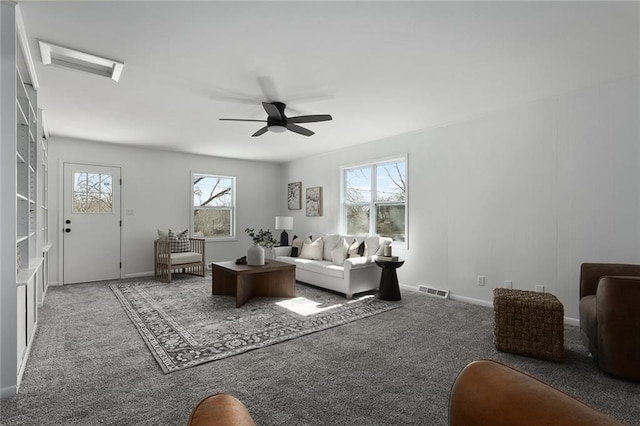 living area with carpet floors, visible vents, ceiling fan, and baseboards