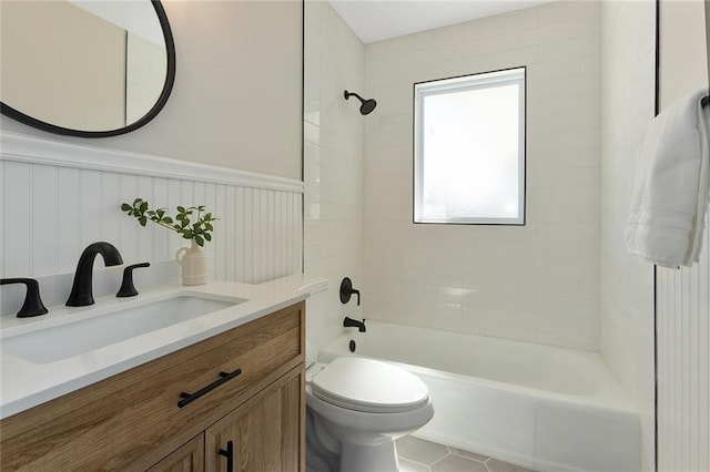 full bathroom featuring tile patterned flooring, toilet, bathing tub / shower combination, vanity, and wainscoting