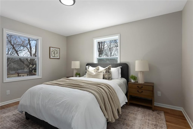 bedroom with baseboards and wood finished floors