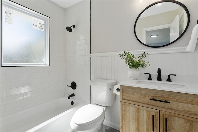 bathroom featuring wainscoting, vanity, toilet, and tub / shower combination