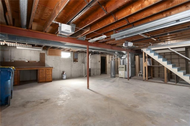 basement with water heater, stairs, and heating unit