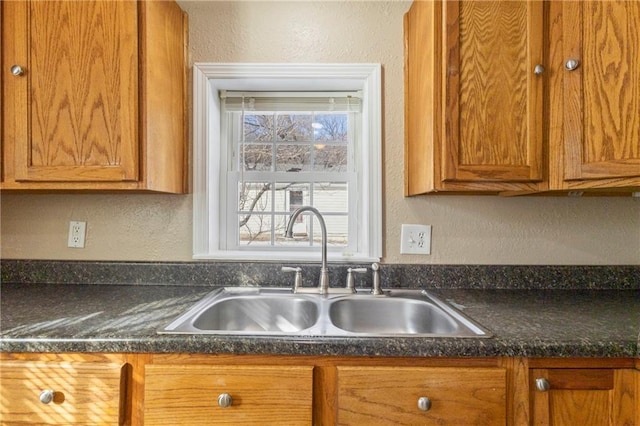 kitchen featuring sink and dark stone counters