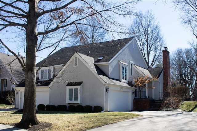 view of front of house featuring concrete driveway, a chimney, roof with shingles, an attached garage, and stucco siding